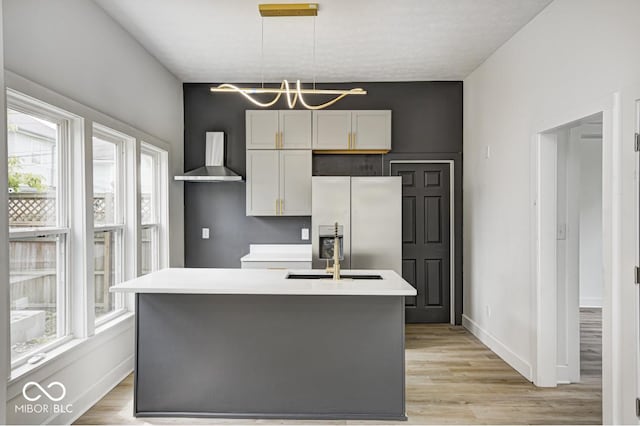 815 E 24th St E, Indianapolis, IN 46205 - kitchen featuring stainless steel refrigerator with ice dispenser, wall chimney range hood, plenty of natural light, and a center island with sink