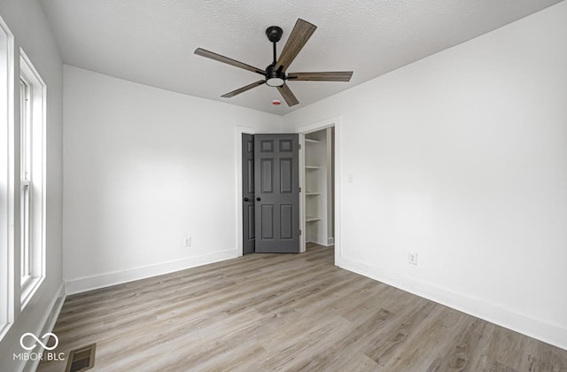 815 E 24th St E, Indianapolis, IN 46205 - spare room featuring a ceiling fan, light wood finished floors, baseboards, and a textured ceiling