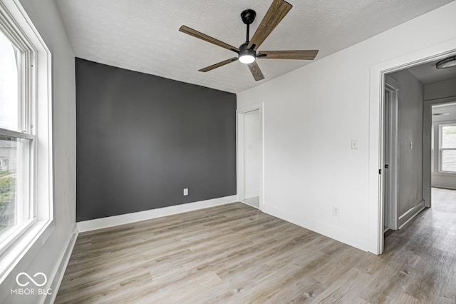 815 E 24th St E, Indianapolis, IN 46205 - empty room featuring ceiling fan, light wood-style flooring, a textured ceiling, and baseboards