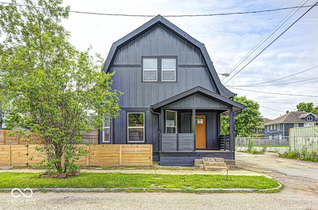 815 E 24th St E, Indianapolis, IN 46205 - dutch colonial with a gambrel roof, covered porch, and a fenced front yard
