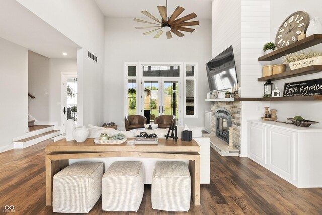 4808 Lakeview Dr, Greenwood, IN 46143 - living area with healthy amount of natural light, a stone fireplace, a ceiling fan, dark wood-type flooring, and a towering ceiling