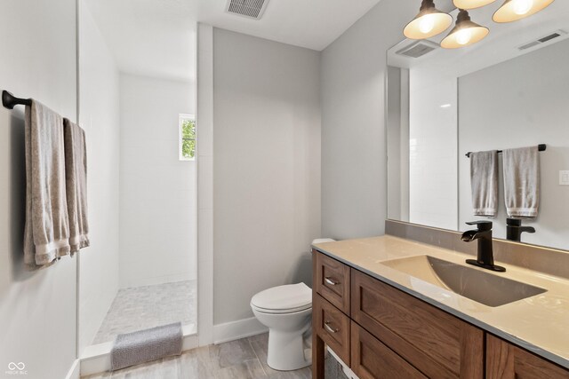 4808 Lakeview Dr, Greenwood, IN 46143 - bathroom featuring vanity, toilet, walk in shower, wood finished floors, and baseboards