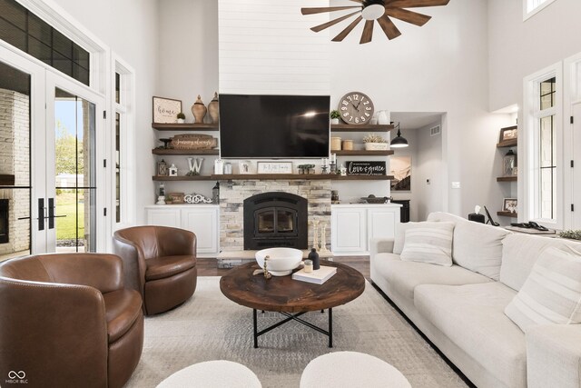 4808 Lakeview Dr, Greenwood, IN 46143 - living room featuring a towering ceiling, a ceiling fan, a stone fireplace, and wood finished floors