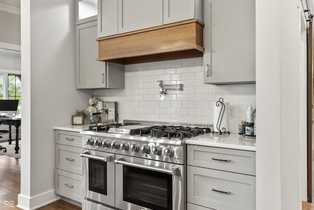 4808 Lakeview Dr, Greenwood, IN 46143 - kitchen with range with two ovens, tasteful backsplash, light countertops, custom range hood, and gray cabinets