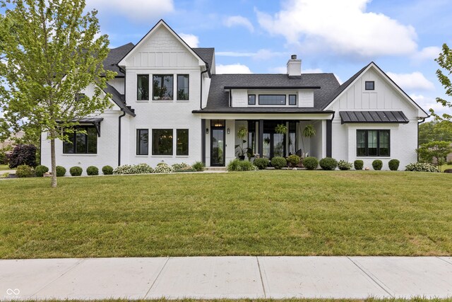 4808 Lakeview Dr, Greenwood, IN 46143 - modern inspired farmhouse with board and batten siding, a front lawn, a chimney, covered porch, and roof with shingles