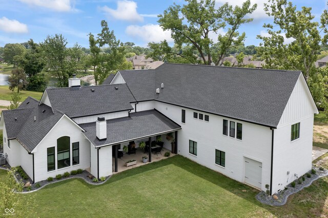 4808 Lakeview Dr, Greenwood, IN 46143 - back of house with a shingled roof, a chimney, a patio area, a lawn, and an attached garage