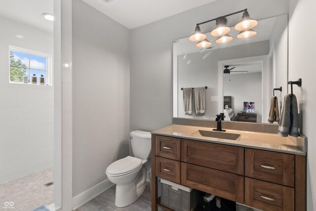 4808 Lakeview Dr, Greenwood, IN 46143 - bathroom featuring vanity, a tile shower, a ceiling fan, toilet, and baseboards