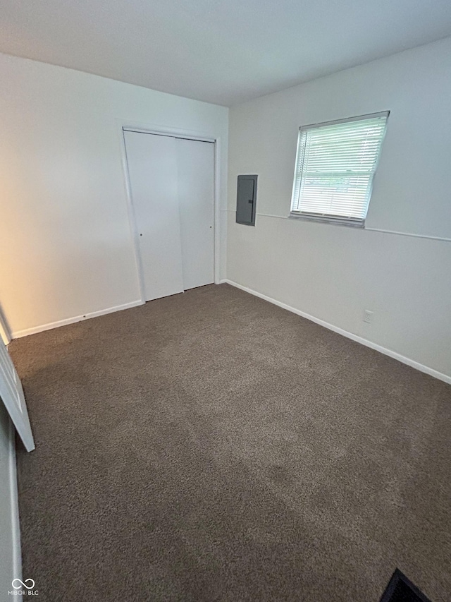 1653 Wade St, Indianapolis, IN 46203 - unfurnished bedroom with electric panel, dark carpet, a closet, and baseboards