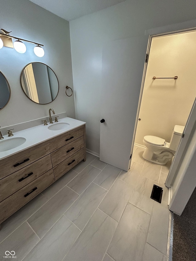 1653 Wade St, Indianapolis, IN 46203 - full bathroom with double vanity, toilet, and marble finish flooring