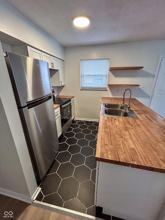 1653 Wade St, Indianapolis, IN 46203 - kitchen featuring stainless steel appliances, a sink, open shelves, baseboards, and white cabinets