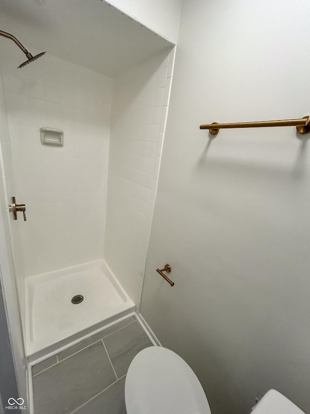 1653 Wade St, Indianapolis, IN 46203 - bathroom with toilet, tiled shower, marble finish flooring, and baseboards