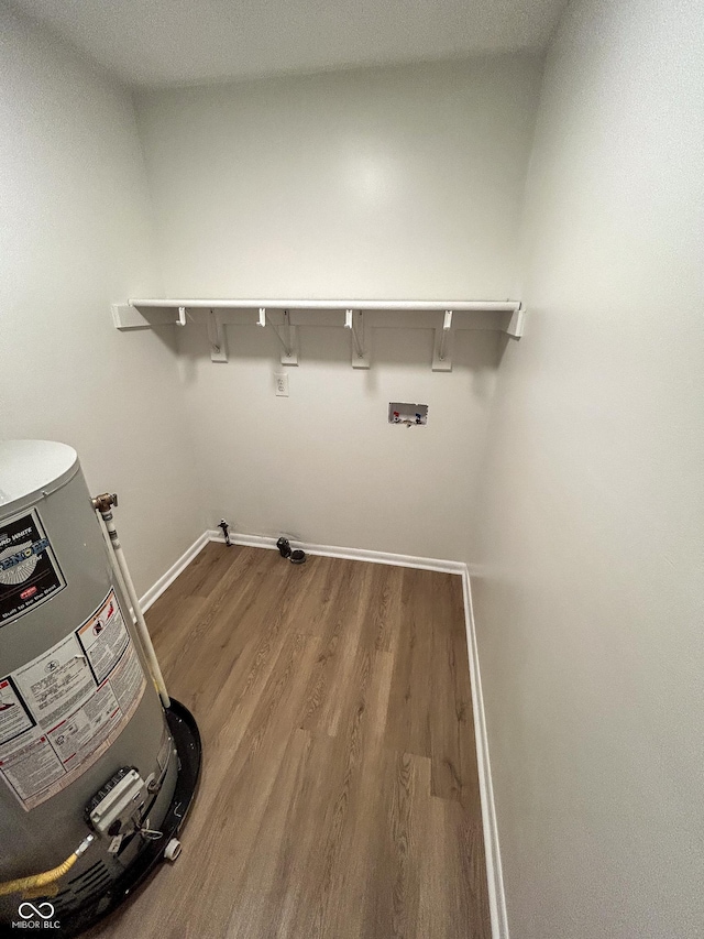 1653 Wade St, Indianapolis, IN 46203 - laundry area with wood finished floors, baseboards, gas water heater, and washer hookup