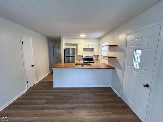 1653 Wade St, Indianapolis, IN 46203 - kitchen with stainless steel appliances, a sink, a peninsula, dark wood finished floors, and butcher block counters