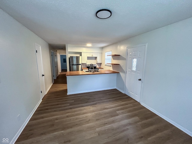 1653 Wade St, Indianapolis, IN 46203 - kitchen with appliances with stainless steel finishes, a peninsula, dark wood-type flooring, and baseboards