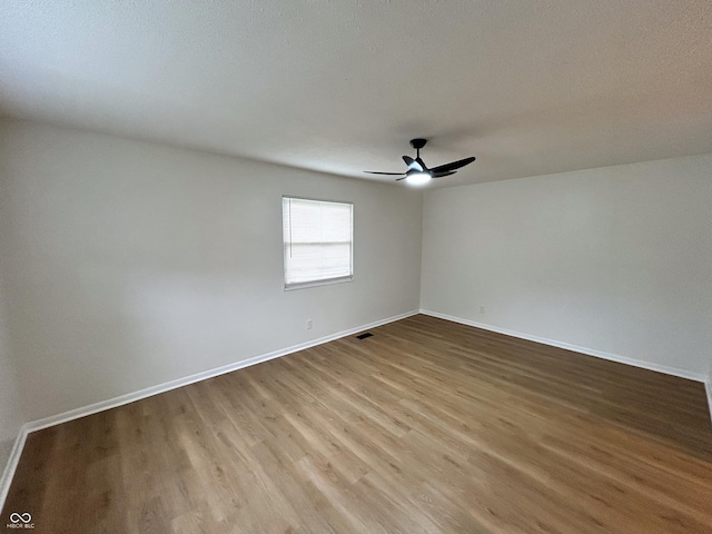 1653 Wade St, Indianapolis, IN 46203 - empty room with a ceiling fan, wood finished floors, and baseboards