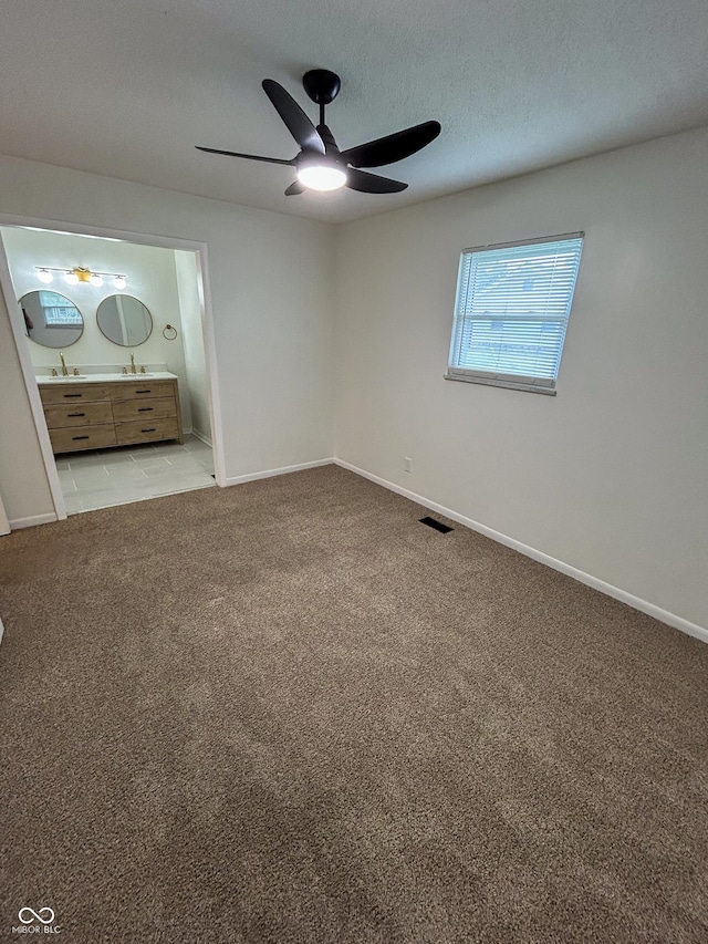 1653 Wade St, Indianapolis, IN 46203 - unfurnished bedroom with light carpet, connected bathroom, baseboards, and a ceiling fan