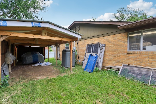 410 E Southport Rd, Indianapolis, IN 46227 - view of side of property with central AC unit, brick siding, a yard, and a carport