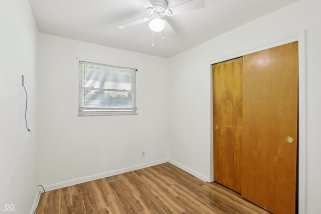 410 E Southport Rd, Indianapolis, IN 46227 - unfurnished bedroom with wood finished floors, baseboards, a closet, and a ceiling fan