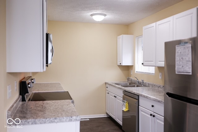 8361 Paso Del Norte Ct, Indianapolis, IN 46227 - kitchen featuring appliances with stainless steel finishes, a sink, white cabinetry, baseboards, and a textured ceiling
