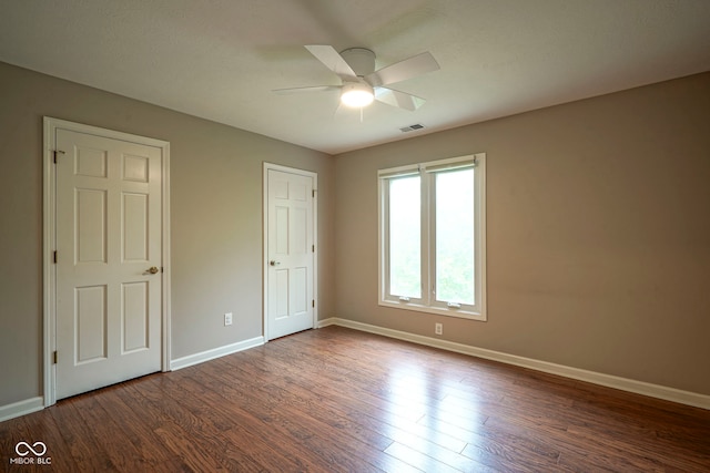4949 Jennings Dr, Carmel, IN 46033 - unfurnished bedroom featuring baseboards, dark wood-type flooring, and a ceiling fan