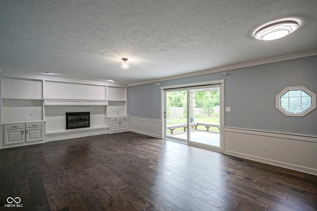 4949 Jennings Dr, Carmel, IN 46033 - unfurnished living room featuring a textured ceiling, ornamental molding, dark wood-type flooring, a fireplace, and a wainscoted wall
