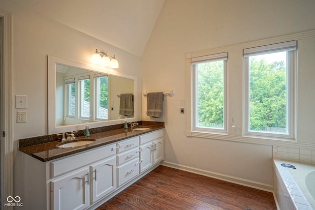 4949 Jennings Dr, Carmel, IN 46033 - full bath with double vanity, vaulted ceiling, tiled bath, wood finished floors, and baseboards