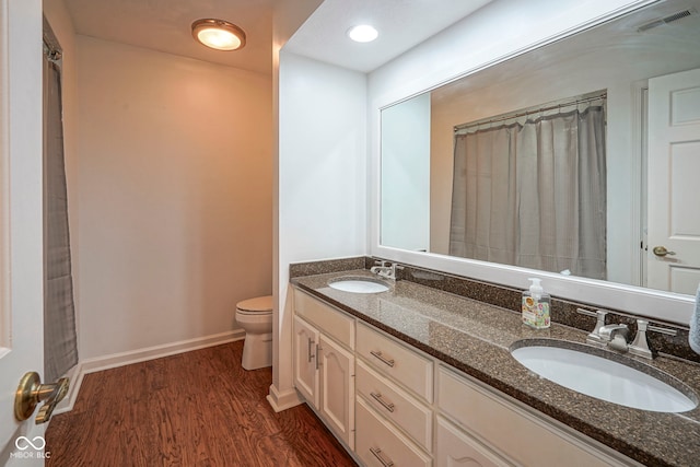 4949 Jennings Dr, Carmel, IN 46033 - full bathroom featuring toilet, double vanity, wood finished floors, and baseboards