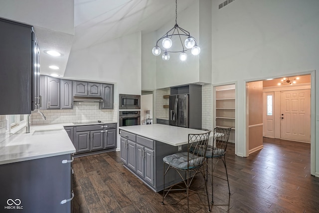 4949 Jennings Dr, Carmel, IN 46033 - kitchen featuring gray cabinets, stainless steel appliances, high vaulted ceiling, a sink, and under cabinet range hood