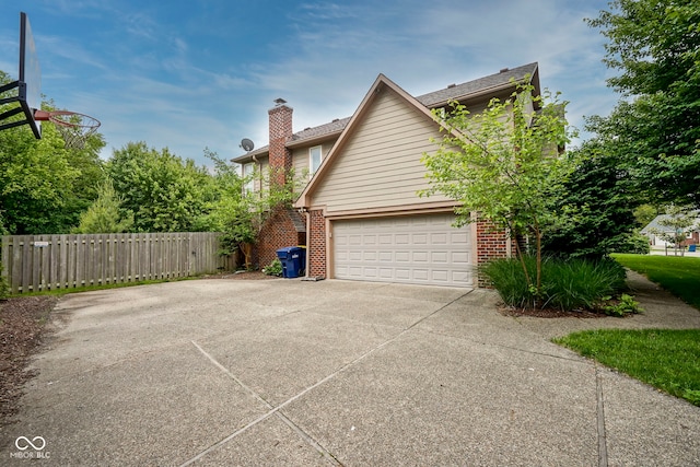 4949 Jennings Dr, Carmel, IN 46033 - view of property exterior featuring brick siding, a chimney, and driveway