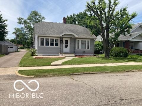 1728 Newton St, Columbus, IN 47201 - bungalow featuring a chimney, a front lawn, and a garage