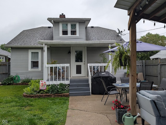 1728 Newton St, Columbus, IN 47201 - back of property with roof with shingles, a chimney, a porch, and outdoor dining area