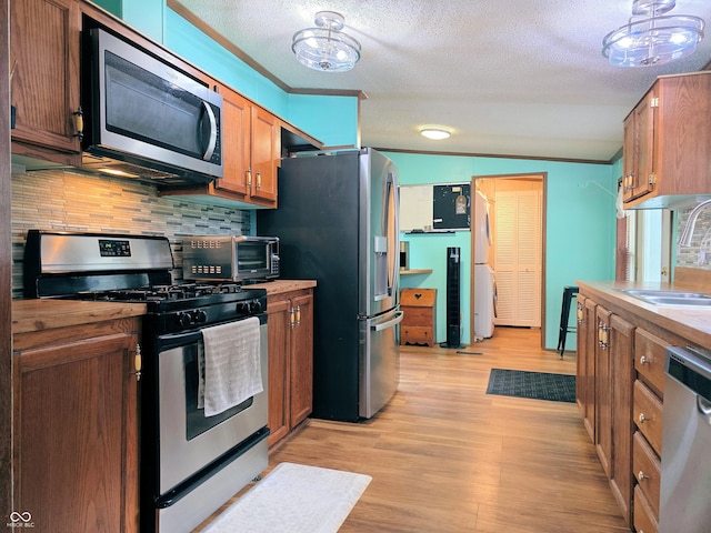 8310 Dog Trot Ln, Morgantown, IN 46160 - kitchen featuring stainless steel appliances, a sink, backsplash, light wood-type flooring, and a textured ceiling