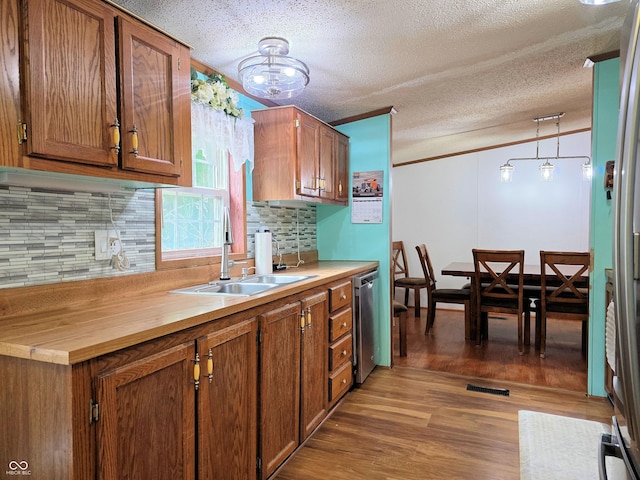 8310 Dog Trot Ln, Morgantown, IN 46160 - kitchen with a sink, light wood finished floors, decorative backsplash, a textured ceiling, and dishwasher