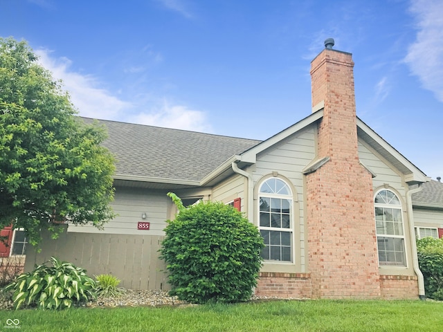 855 Gazebo Way Unit C, Greenwood, IN 46142 - view of side of property with a shingled roof, a chimney, brick siding, and an attached garage