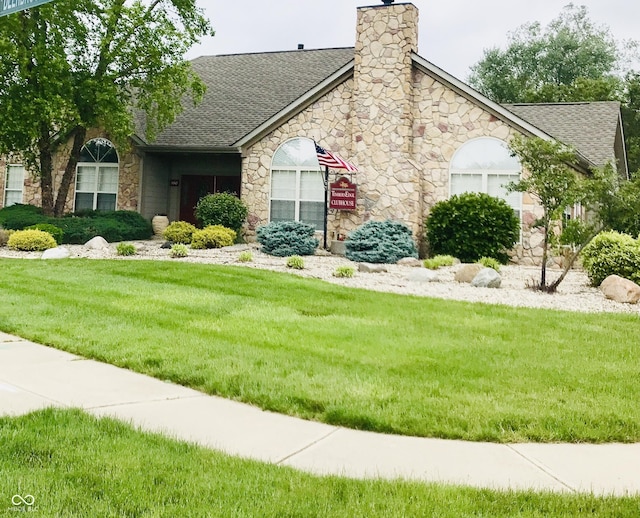 855 Gazebo Way Unit C, Greenwood, IN 46142 - view of front of property with stone siding, roof with shingles, a front lawn, and a chimney