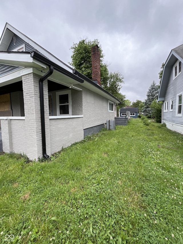 3526 Evergreen Ave, Indianapolis, IN 46205 - view of property exterior with a chimney, brick siding, and a yard