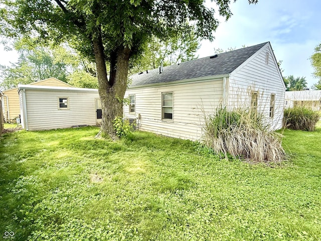 910 Lonsvale Dr, Anderson, IN 46013 - rear view of property with a lawn, roof with shingles, and central AC