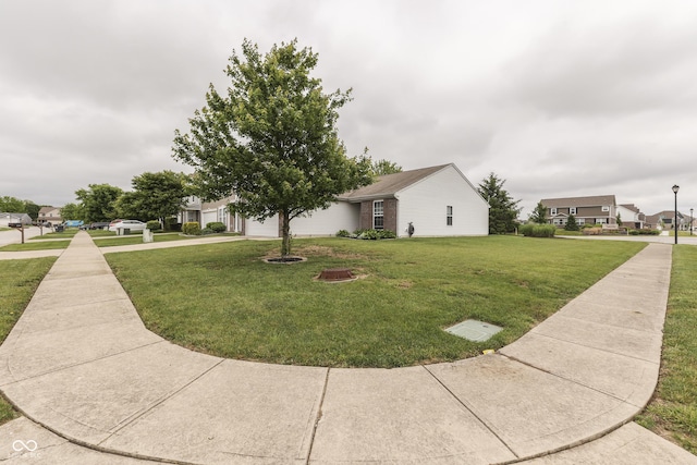 933 Curlew Ln, Greenwood, IN 46143 - view of front of house with a front yard, an attached garage, a residential view, and concrete driveway
