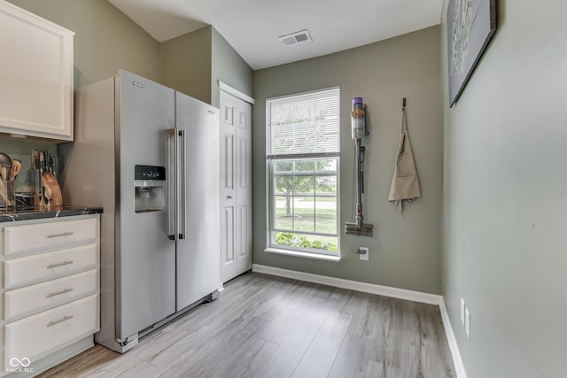 933 Curlew Ln, Greenwood, IN 46143 - kitchen featuring stainless steel fridge, light wood-style floors, white cabinetry, and baseboards