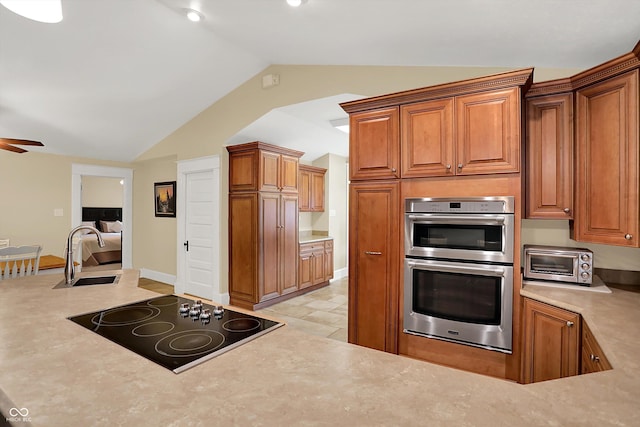 203 N Cross St, Hillsboro, IN 47949 - kitchen featuring black electric cooktop, double oven, vaulted ceiling, ceiling fan, and light countertops
