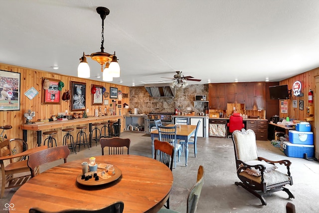 203 N Cross St, Hillsboro, IN 47949 - dining room featuring wood walls, ceiling fan, concrete flooring, and a chandelier