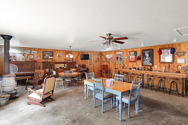 203 N Cross St, Hillsboro, IN 47949 - dining room featuring concrete flooring, wooden walls, and ceiling fan