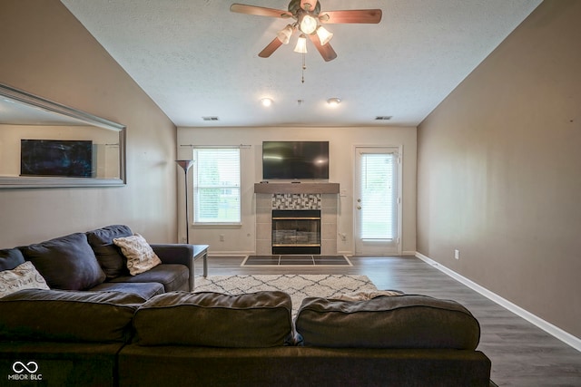7724 Blackthorn Dr, Indianapolis, IN 46236 - living area with healthy amount of natural light, a tile fireplace, baseboards, lofted ceiling, and a textured ceiling