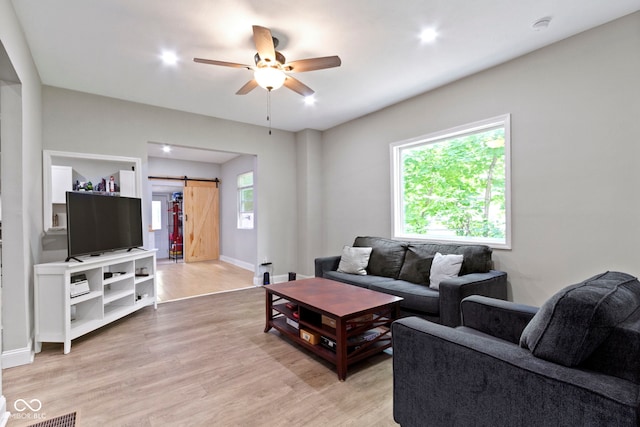 1150 W 30th St, Indianapolis, IN 46208 - living area featuring a barn door, ceiling fan, light wood-style floors, and baseboards