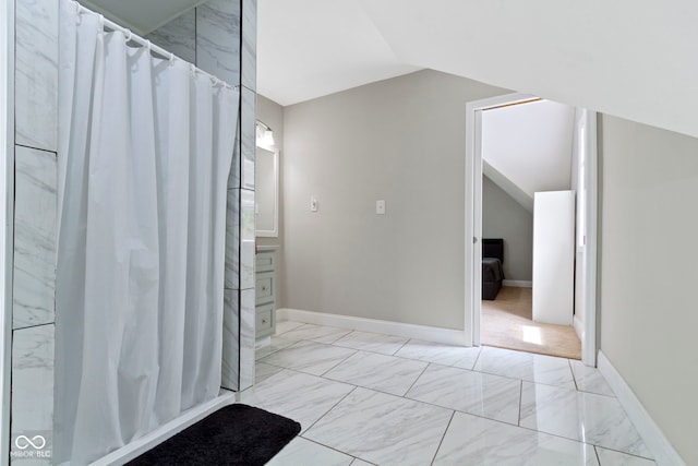 1150 W 30th St, Indianapolis, IN 46208 - bathroom featuring lofted ceiling, marble look tile flooring, curtained shower, and baseboards