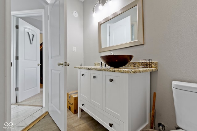 1150 W 30th St, Indianapolis, IN 46208 - half bathroom featuring vanity, wood finished floors, and toilet
