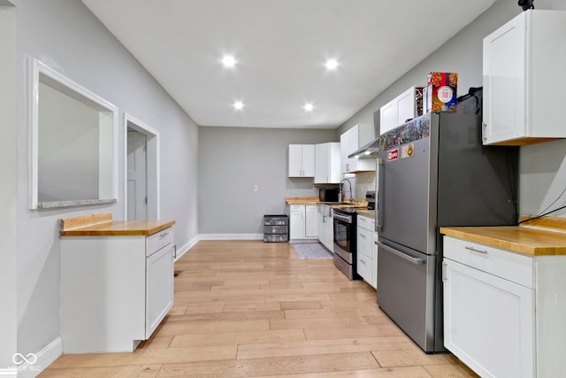 1150 W 30th St, Indianapolis, IN 46208 - kitchen featuring wooden counters, appliances with stainless steel finishes, light wood finished floors, white cabinetry, and recessed lighting