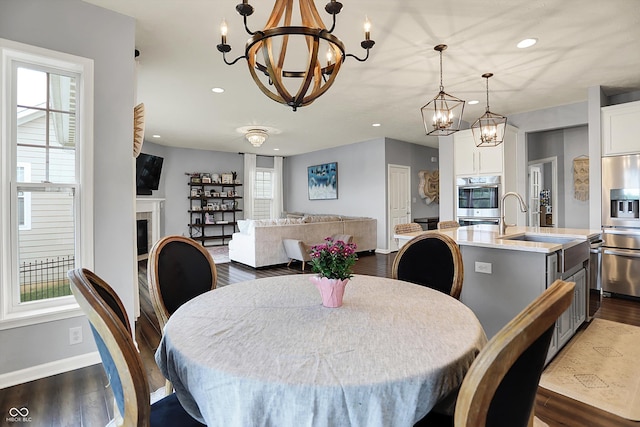 1071 Serenity Ct, Carmel, IN 46280 - dining room with a chandelier, dark wood finished floors, baseboards, recessed lighting, and a fireplace