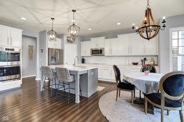 1071 Serenity Ct, Carmel, IN 46280 - kitchen with appliances with stainless steel finishes, a chandelier, a sink, backsplash, and recessed lighting