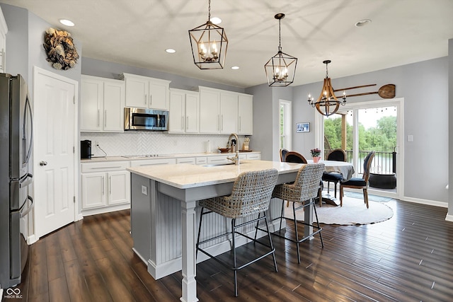 1071 Serenity Ct, Carmel, IN 46280 - kitchen featuring stainless steel appliances, a chandelier, a sink, dark wood-style floors, and recessed lighting